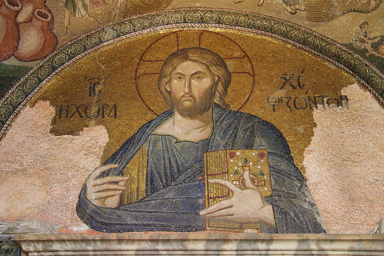 Ancient Byzantine mosaic of Jesus Christ, known as Christ Pantocrator, in the Hagia Sophia, with a golden halo, holding a bejeweled book, against a gold background, displaying traditional Christian iconography and inscriptions in Greek.