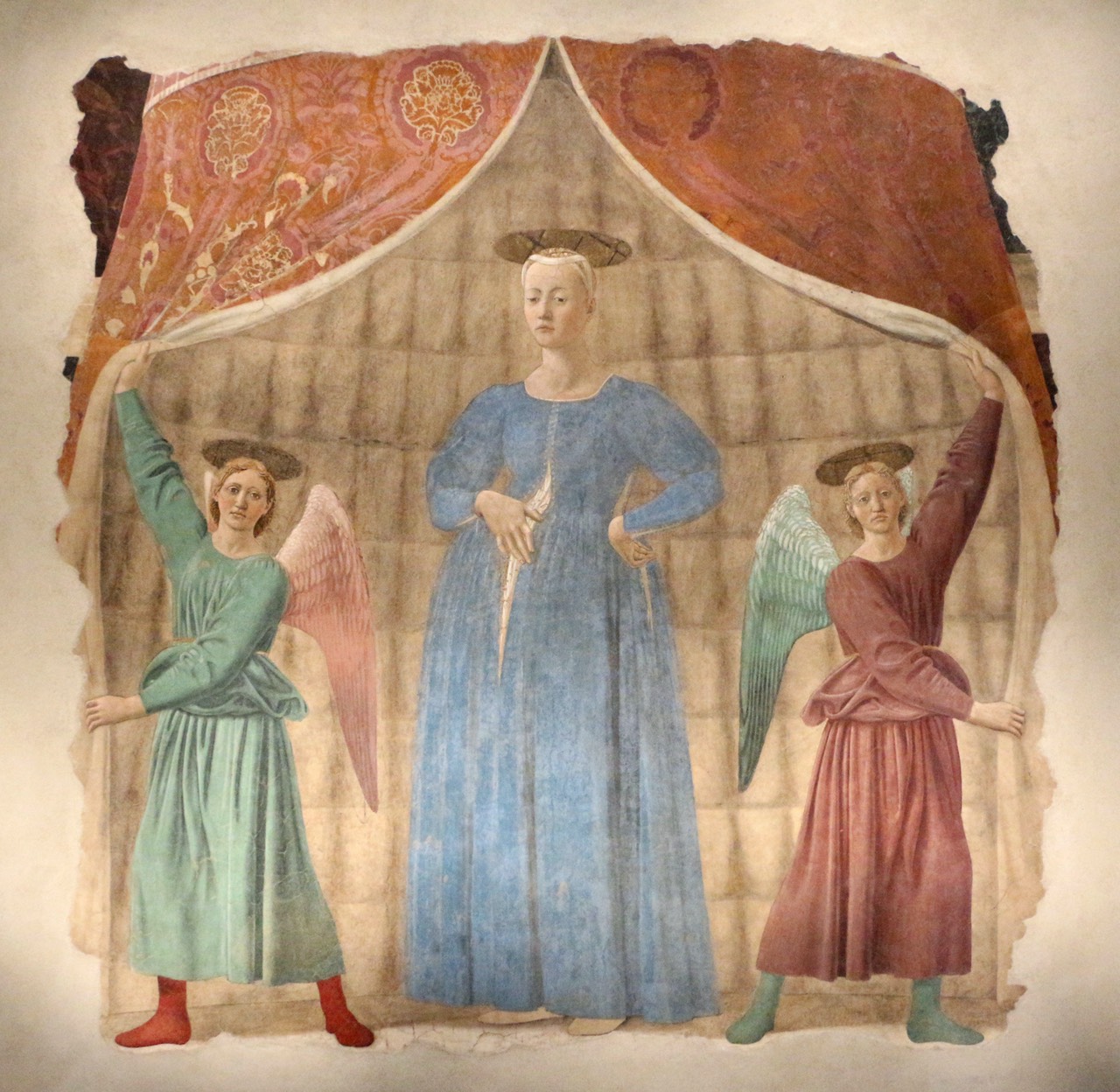 A fresco depicting the Madonna del Parto with two angels holding a tent, in muted earth tones.